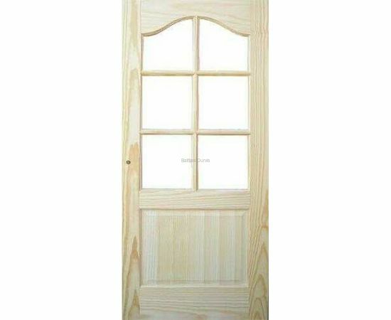 Priedes masīvkoka iekšdurvis DAKOTA ar koka apdari un lielu līstotu stikla pildiņu durvju augšdaļā, kas rada gaismas caurlaidīgu un atvērtu telpas sajūtu.